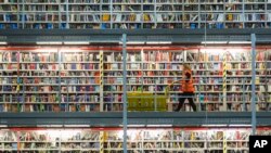 An employee works in the distribution center of the online retailer Amazon during a guided press tour prior to the upcoming Christmas business in Leipzig, central Germany.