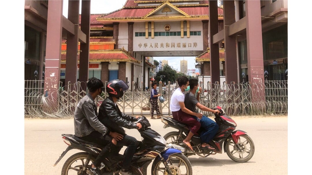 FILE - Motorists pass the China-Myanmar border gate in Muse in Shan state on July 5, 2021, as the Chinese city of Ruili near the border with Myanmar imposed a lockdown and started mass testing.