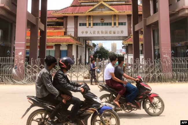 FILE - Motorists pass the China-Myanmar border gate in Muse in Shan state on July 5, 2021, as the Chinese city of Ruili near the border with Myanmar imposed a lockdown and started mass testing.