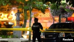 FILE - A police officer guards the scene of a mass shooting in Toronto, Canada, July 22, 2018. 