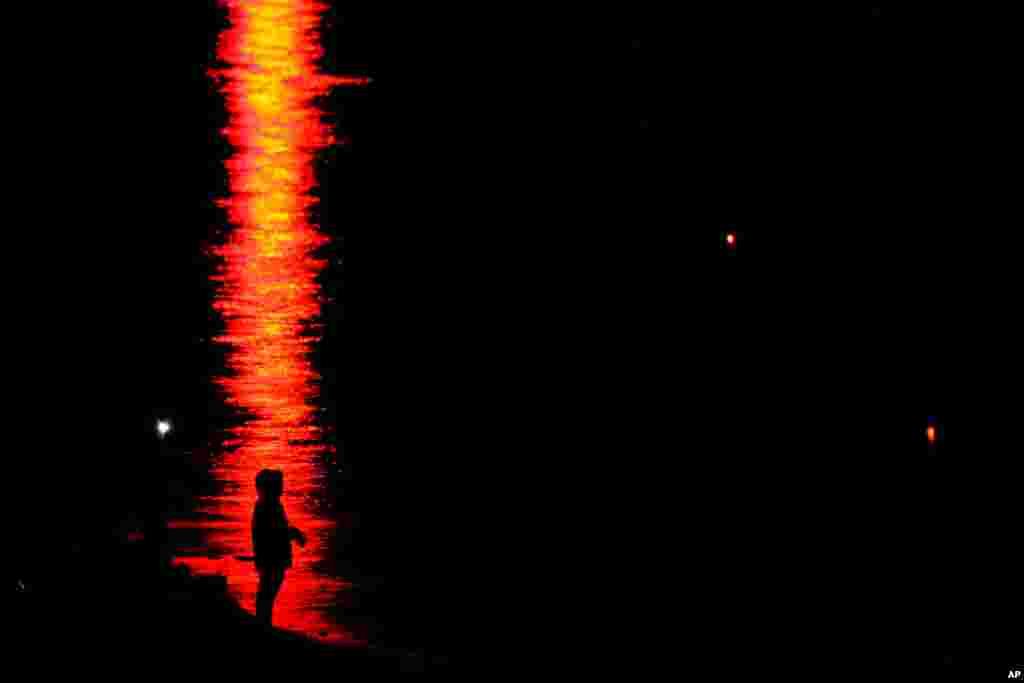 A person is silhouetted on the water while fishing at Clinton Reservoir, April 26, 2020, near Lawrence, Kansas.