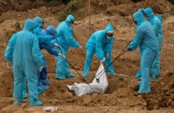 A health worker and relatives bury the body of a man who died from the coronavirus disease (COVID-19), at a graveyard in New Delhi, India, May 6, 2020.