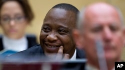 Kenya's president Uhuru Kenyatta smiles as he sits with his defense team during an appearance at the International Criminal Court in The Hague, Netherlands on Oct. 8, 2014.