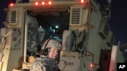 A US Army soldier smiles after crossing into Kuwait as the last convoy pulls out of Iraq, December 18, 2011.