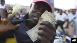 FILE: Worn out or shredded by rats, $1 notes are king in Zimbabwe, beset by a continuing economic crisis. One dollar bills are used by many people to buy their daily bread and other small purchases. (AP)