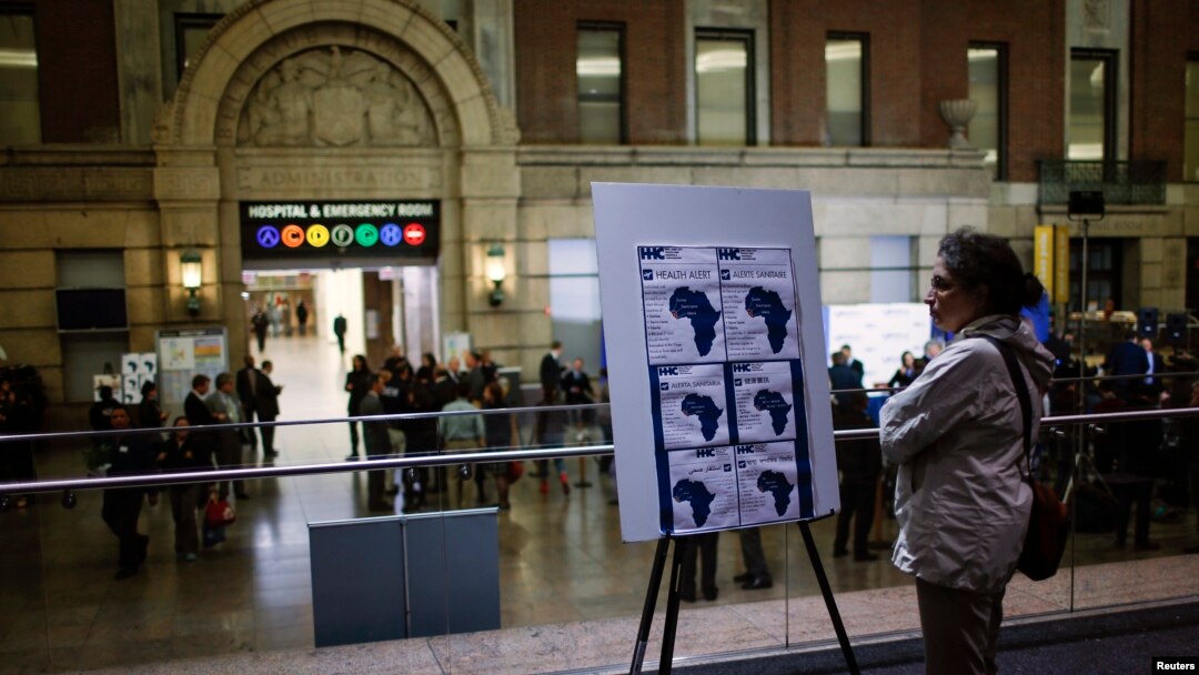 A woman reads an Ebola alert at Bellevue Hospital, where Dr. Craig Spencer is being treated for symptoms in New York Oct. 23, 2014. 