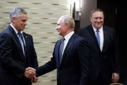 FILE - Russian President Vladimir Putin shakes hands with U.S. Ambassador to Russia Jon Huntsman as U.S. Secretary of State Mike Pompeo stands behind prior to their talks in the Black Sea resort city of Sochi, May 14, 2019.