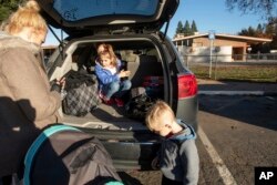 Bella Maloney, 8, arrives for her first day of school since the Camp Fire leveled her family's home, in Durham, Calif., Dec. 3, 2018.