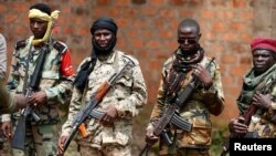FILE - Seleka fighters warily eye a photographer at their base in Bambari, Central African Republic, on May 31, 2014. 