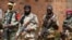 FILE - Seleka fighters warily eye a photographer at their base in Bambari, Central African Republic, on May 31, 2014. 