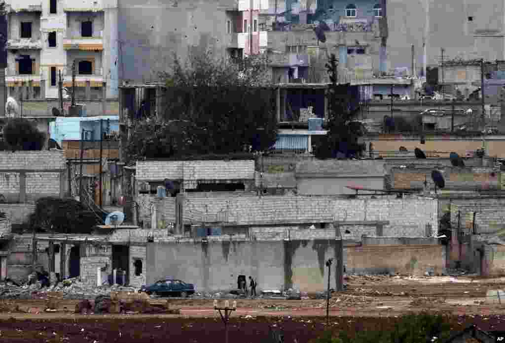 Kurdish fighters enter their positions in a house in Kobani, Syria, Oct. 16, 2014.