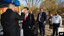 Petugas memeriksa suhu tubuh para wartawan dan anggota staf Gedung Putih sebelum memasuki kawasan Gedung Putih, Washington D.C, 16 Maret 2020. (Foto: AP)