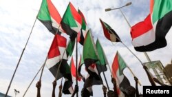 Sudanese women hold a banner bearing pictures of killed protesters during a demonstration called for by the Sudanese Professionals Association (SPA), in the capital Khartoum, Aug. 1, 2019.