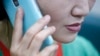 FILE - A North Korean defector living in South Korea uses her mobile phone during an interview at her office in Seoul.