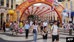 这张照片拍摄于2023年10月3日，显示中国游客在10月初为期一周的假期期间走过澳门的塞纳多广场。（法新社）