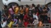 Cambodian garment factory workers ride on the back of a truck as they head to work outside Phnom Penh, Cambodia, Tuesday, Sept. 22, 2020. (AP Photo/Heng Sinith)