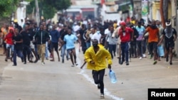 People charge towards the police during a nationwide strike called by Mozambique presidential candidate Venancio Mondlane to protest the provisional results of an Oct. 9 election, in Maputo, Mozambique, Oct. 21, 2024. 