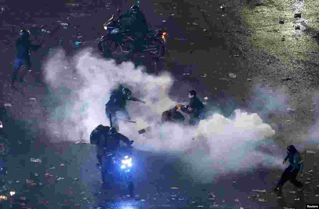 Riot police detain a demonstrator after Argentina lost to Germany in their 2014 World Cup final soccer match in Brazil, at a public square viewing area in Buenos Aires, July 13, 2014.