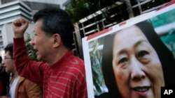 FILE - Anti-Beijing protesters hold a picture of veteran Chinese journalist Gao Yu during a rally outside the Chinese central government's liaison office in Hong Kong, as they demand the release of Gao, Nov. 27, 2015.