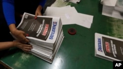 Pressroom workers pack an edition of the newspaper Danas in Belgrade, Serbia, Sept. 27, 2017. The paper bears a white inscription that warns: "This is what it looks like when there is no free press!" 