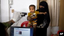 FILE - A Bangladeshi officer takes the photograph of a Rohingya boy while his mother holds him during the process of registration at Kutupalong refugee camp near Cox's Bazar, Bangladesh, Jan. 16, 2018.