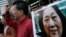 抗议人士在中国中央政府驻香港联络处外举行集会手举高瑜照片要求释放高瑜。著名媒体人高瑜曾经被电视认罪.（2015年11月27日）