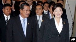 Cambodia's Prime Minister Hun Sen, left, walks with his Thai counterpart Yingluck Shinawatra as they attend ASEAN-UN Summit in Nusa Dua, Bali, Indonesia, Saturday, Nov. 19, 2011. 