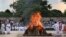 Flames rise from the funeral pyre of former Indian Prime Minister Atal Bihari Vajpayee, watched by his foster daughter Namita Bhattacharya on the banks of the River Yamuna in New Delhi, India, Aug. 17, 2018. 