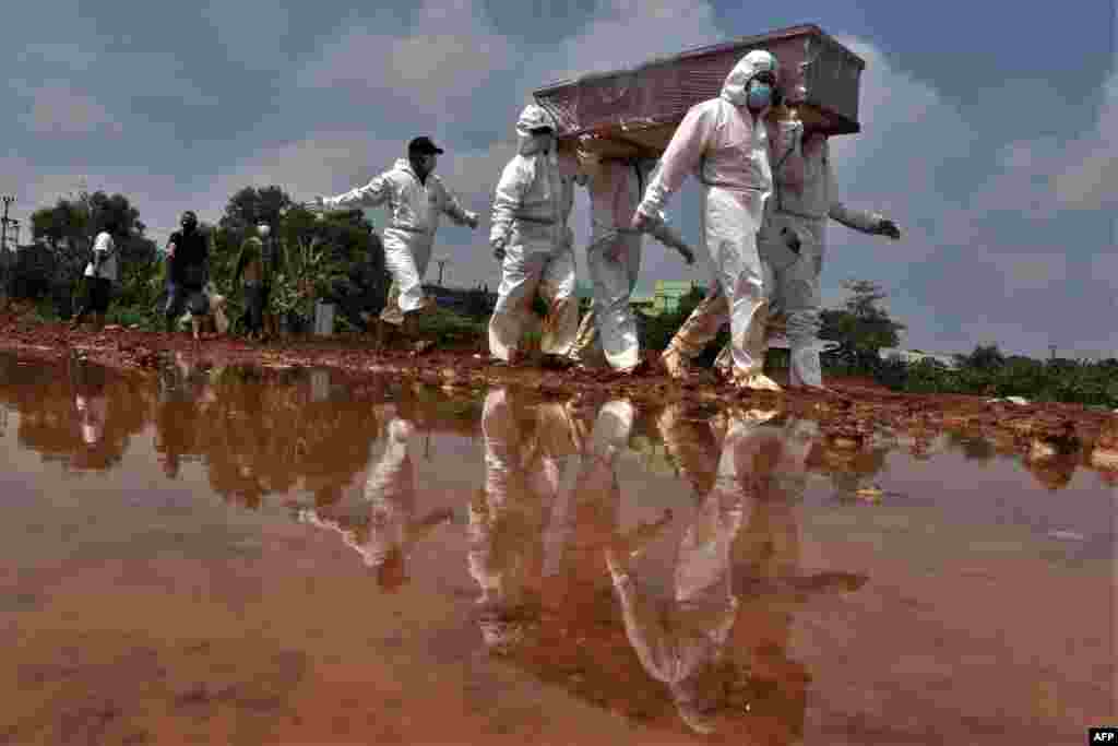 Grave diggers carry the coffin of a victim who died from COVID-19 for burial at a cemetery in Bekasi, Indonesia.