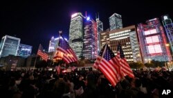 Protester holds U.S. flags during a demonstration in Hong Kong, Thursday, Nov. 28, 2019. 