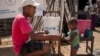 Un membre de l'ONG Action Contre la Faim donne de l'eau potable à un nourrisson lors d'une séance de dépistage de la malnutrition dans la commune d'Ifotaka, dans le sud de Madagascar, le 14 décembre 2018.