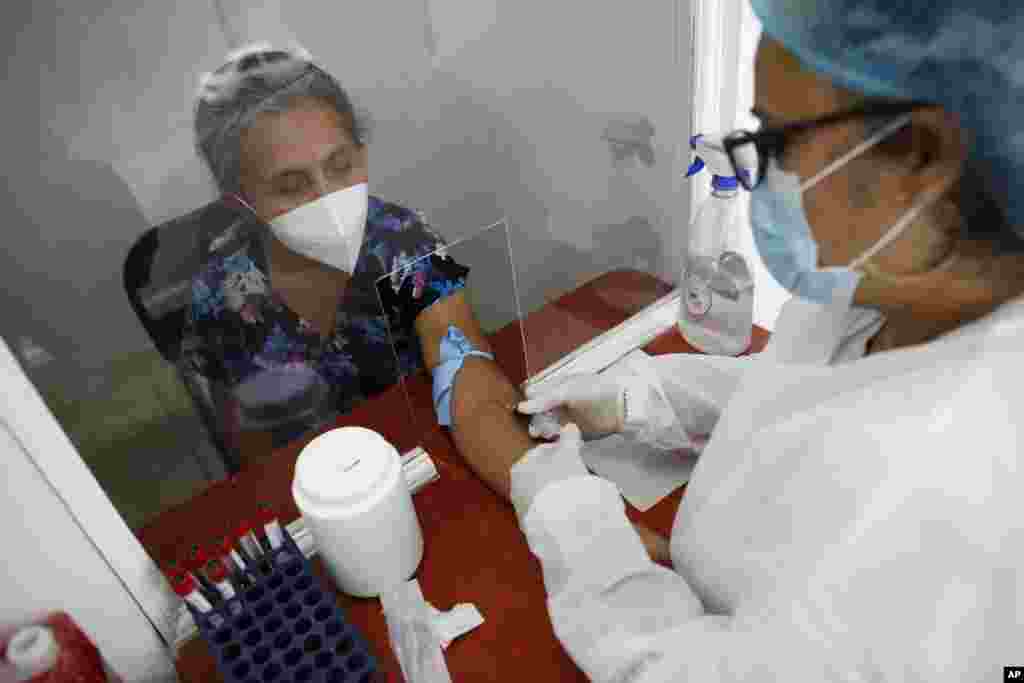 Norma Gonzalez, 68, is tested for the COVID-19 virus, in a Red Cross laboratory in Tegucigalpa, Honduras, Friday, April 23, 2021. (AP Photo/Elmer Martinez)