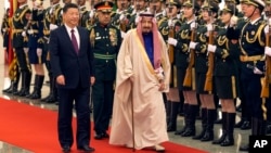 Presiden China Xi Jinping dan Raja Arab Saudi Salman menginspeksi pasukan dalam upacara penyambutan di Beijing (16/3). (AP/Ng Han Guan)