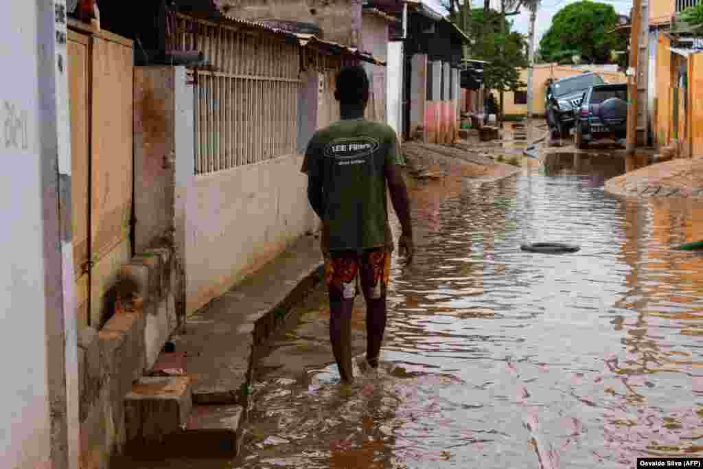 Um morador caminha pela &#225;gua numa rua do Futungo, Luanda - Angola, a 20 de Abril, depois das fortes chuvas de 19 .