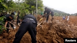 Rescue workers conduct a search at the site of a landslide at the Koslanda tea plantation near Haldummulla, October 30, 2014.