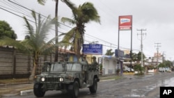 A navy vehicle drives along a street in the coastal town of Barra de Navidad as the community prepares for the arrival of Hurricane Bud along the Pacific coast of Mexico, May 25, 2012. 