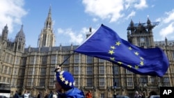 An anti-Brexit campaigner shows her support for Europe waving a European Union flag outside Parliament in London, March 25, 2019. 