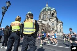 Police officers patrol a half-marathon in front of the Berlin Cathedral, in Berlin, Germany, April 8, 2018.