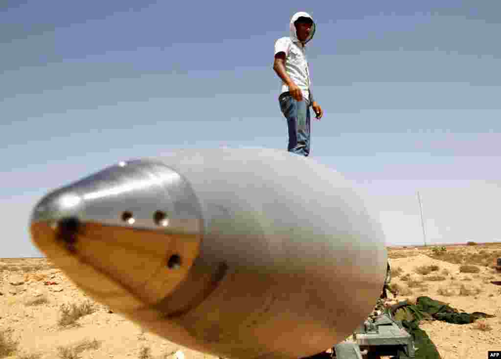 September 1: An anti-Gaddafi fighter stands on an SA-5 SAM missile in Burkan air defense military base, which was destroyed by a NATO air strike. REUTERS/Goran Tomasevic
