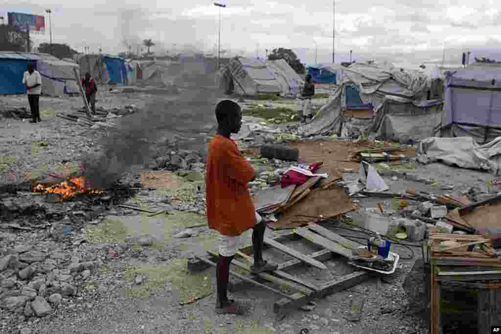 A youth stands among debris from tents disassembled by authorities who closed the camp occupied by people displaced by the 2010 earthquake near the airport in Port-au-Prince, Haiti, January. 4, 2012. (AP)