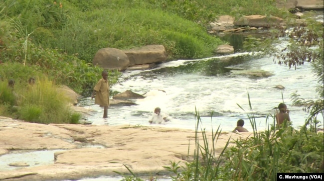 Children bath and swim in a river as people turn to unprotected sources of water in Harare, Zimbabwe, March 7, 2019.
