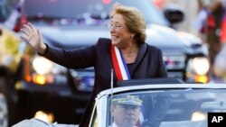 FILE - Chile's new President Michelle Bachelet waves from a car heading to La Moneda presidential palace in Santiago, March 11, 2014. 