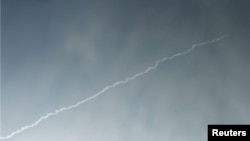 The trail of a flying object is seen in the air above North Korean territory from the Chinese border city of Dandong, in this Feb. 7, 2016 photo.