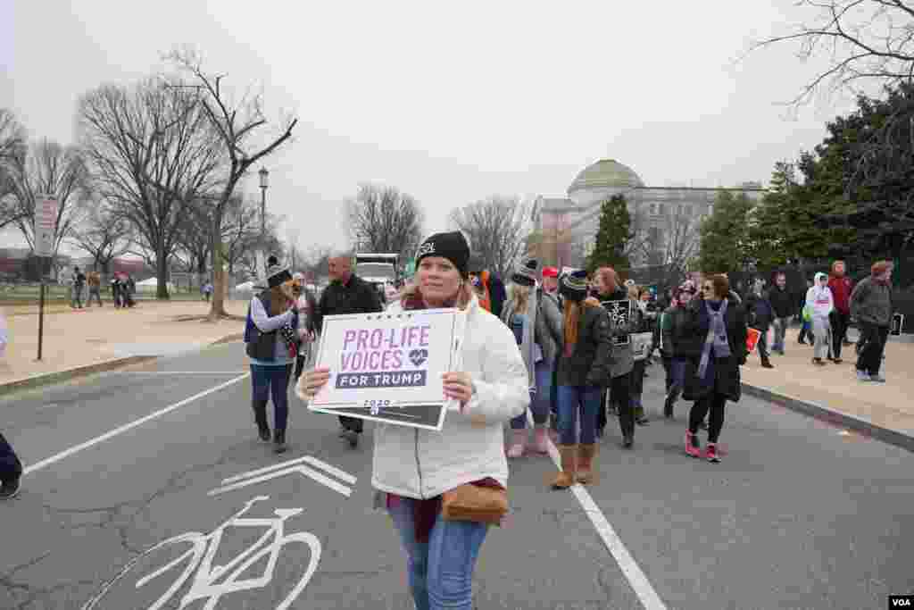 Una mujer sostiene una pancarta que dice: &quot;Las voces pro vida están con Trump&quot;. Es la primera vez que un presidente de Estados Unidos participa en esta marcha.