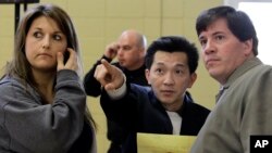 Former U.S. Rep. Anh "Joseph" Cao, center, speaks with BP oil spill fund claimant Kim Chauvin, left, and Cao aide Murray Nelson, right, after a town hall meeting in Houma, La., Tuesday, Jan. 11, 2011. (AP File Photo/Patrick Semansky)