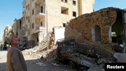 A man looks at damage at a site hit by what activists said was an airstrike by forces loyal to Syria's President Bashar al-Assad in Raqqa, an Islamic State power base in Syria, Sept. 8, 2014. 