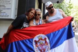 Supporters of Serbian tennis player Novak Djokovic listen to the court decision after his hearing outside his lawyer's office in Melbourne on Jan. 16, 2022. (Photo by Martin Keep / AFP)