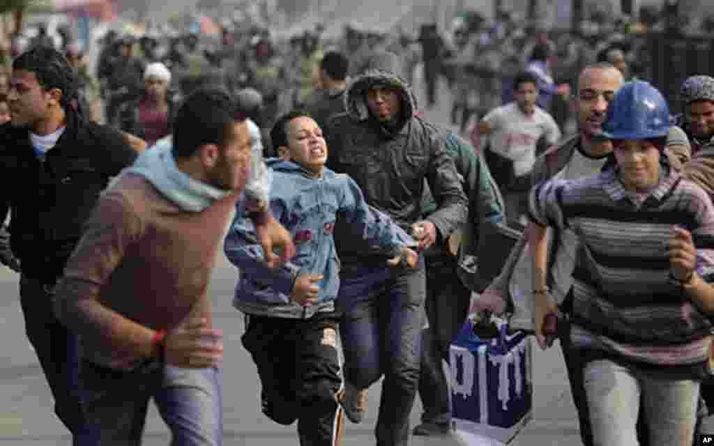 Egyptian protesters run as they are chased by army soldiers over the Asr el-Nile bridge leading out of Tahrir Square, in Cairo, Egypt, Saturday, Dec. 17, 2011. Hundreds of Egyptian soldiers swept into Cairo's Tahrir Square on Saturday, chasing protesters