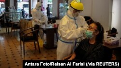 Para petugas medis mengambil sampel untuk tes cepat antigen dari para pengunjung di tengah pandemi virus coronca (COVID-19) di Bandung, Jawa Barat, Rabu, 30 Desember 2020. (Foto: Antara Foto/ Raisan Al Farisi via Reuters)
