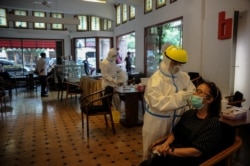 Para petugas kesehatan mengambil sampel untuk tes cepat antigen dari para pengunjung di tengah pandemi virus coronca (COVID-19) di Bandung, Jawa Barat, Rabu, 30 Desember 2020. (Foto: Antara Foto/ Raisan Al Farisi via Reuters)